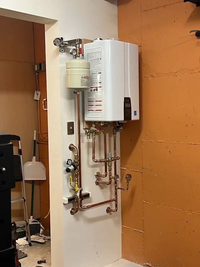 Plumbing technician inspecting water heater connections in West Reading